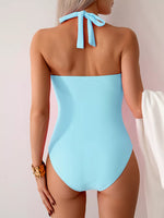 Light blue swimsuit with halter neck design on a neutral background