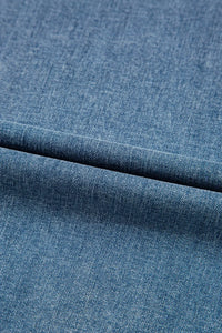 Close-up of blue denim fabric with a visible seam.