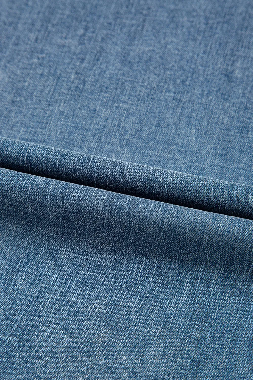 Close-up of blue denim fabric with a visible seam.