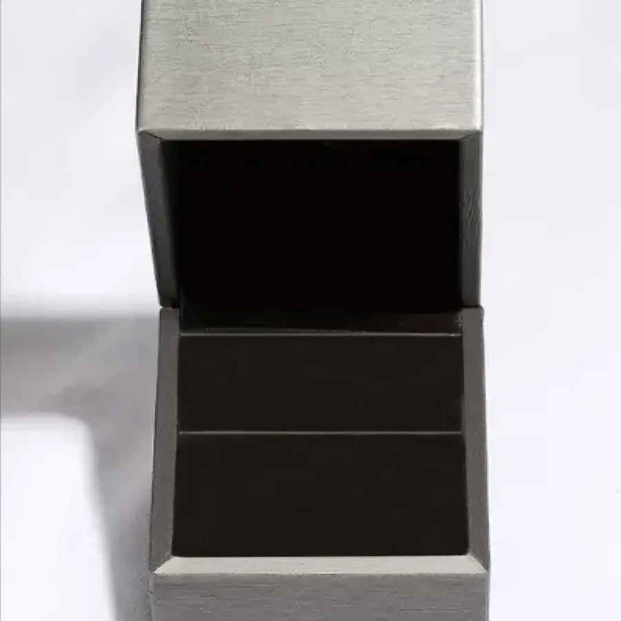 Black rectangular object with textured gray top on a white background