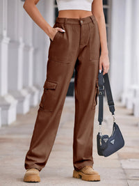Person wearing brown cargo pants holding a blue Prada handbag.