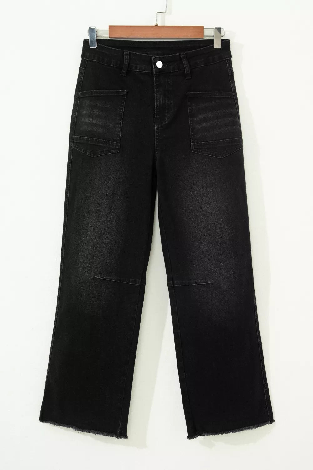 Black jeans on a hanger against a white background