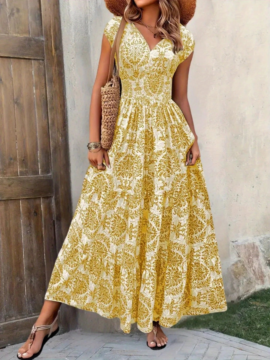 Woman wearing a yellow floral dress standing against a textured wall.