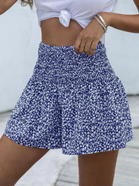 Person wearing a blue floral skirt with a white background