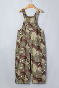 Camouflage overalls on a hanger against a plain background