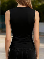 Person wearing a black sleeveless top with blurred background