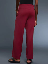 Person wearing maroon pants on a gray background