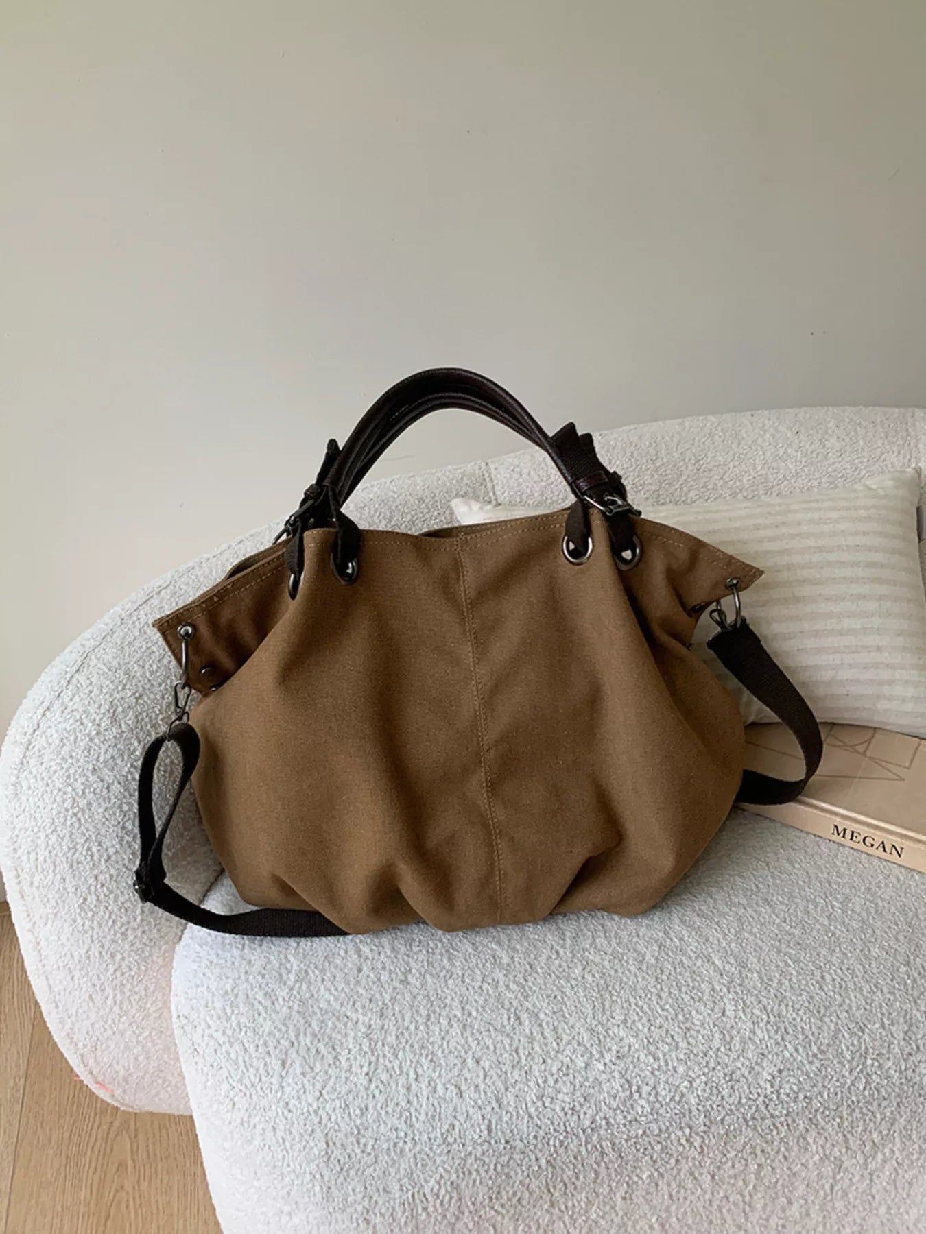 Brown handbag on a textured white surface with a neutral background