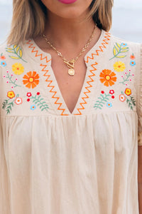 Zoom in view of woman wearing a beige dress