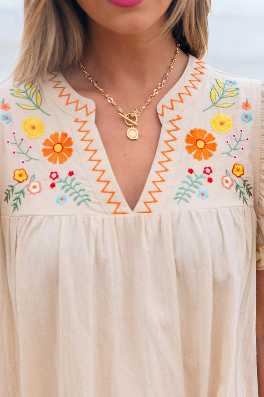 Zoom in view of woman wearing a beige dress