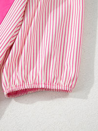 Close-up of a pink and white striped fabric on a textured surface