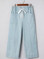 Light blue striped pants with a white drawstring on a gray background