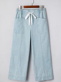Light blue striped pants with a white drawstring on a gray background
