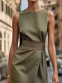 Green dress worn by a person on a blurred city street background