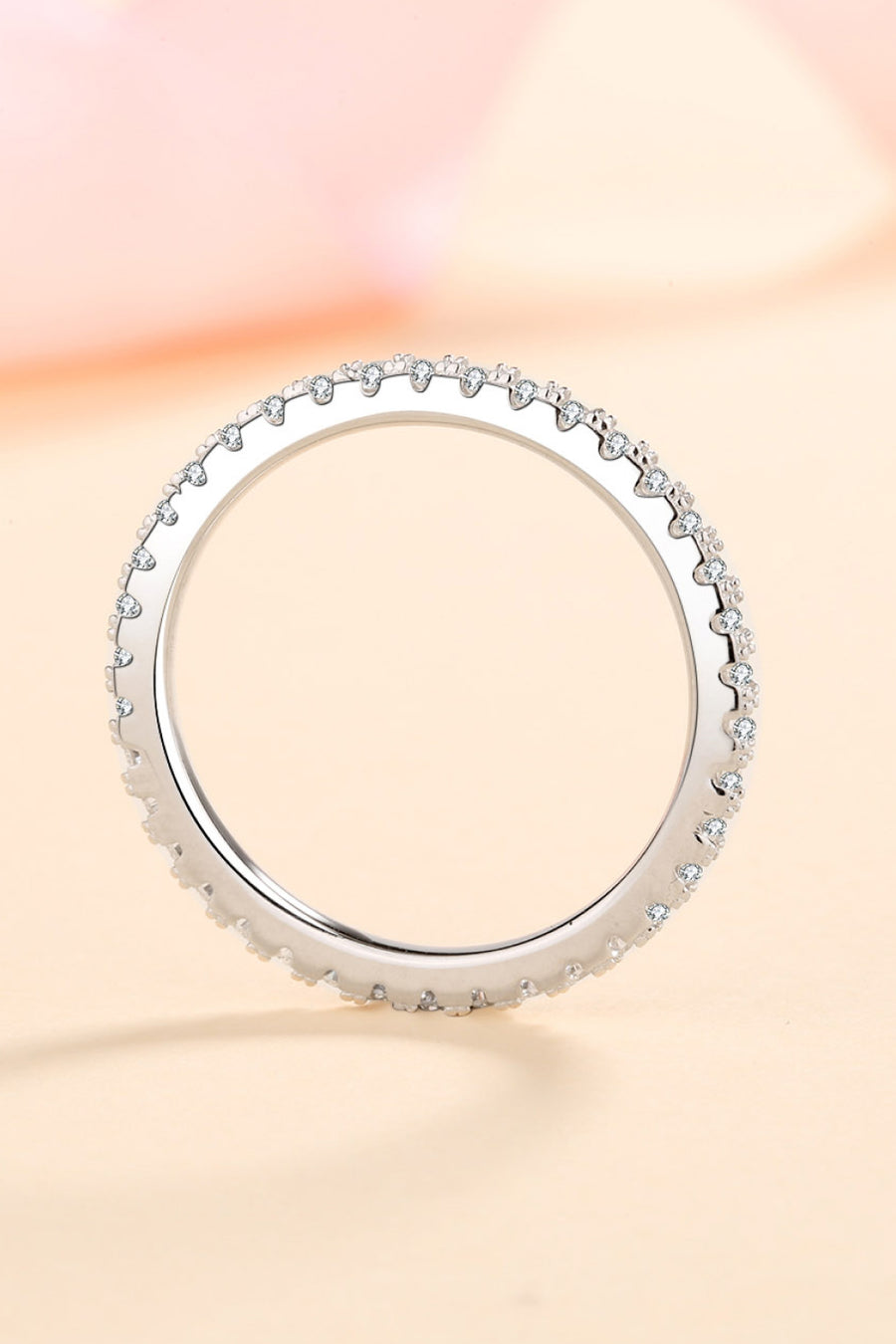 Silver ring with small stones on a gradient background