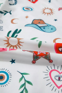 Colorful fabric with various patterns including hearts, stars, and abstract shapes on a white background.