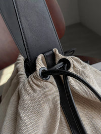 Close-up of a car seat belt being adjusted on a beige fabric surface.