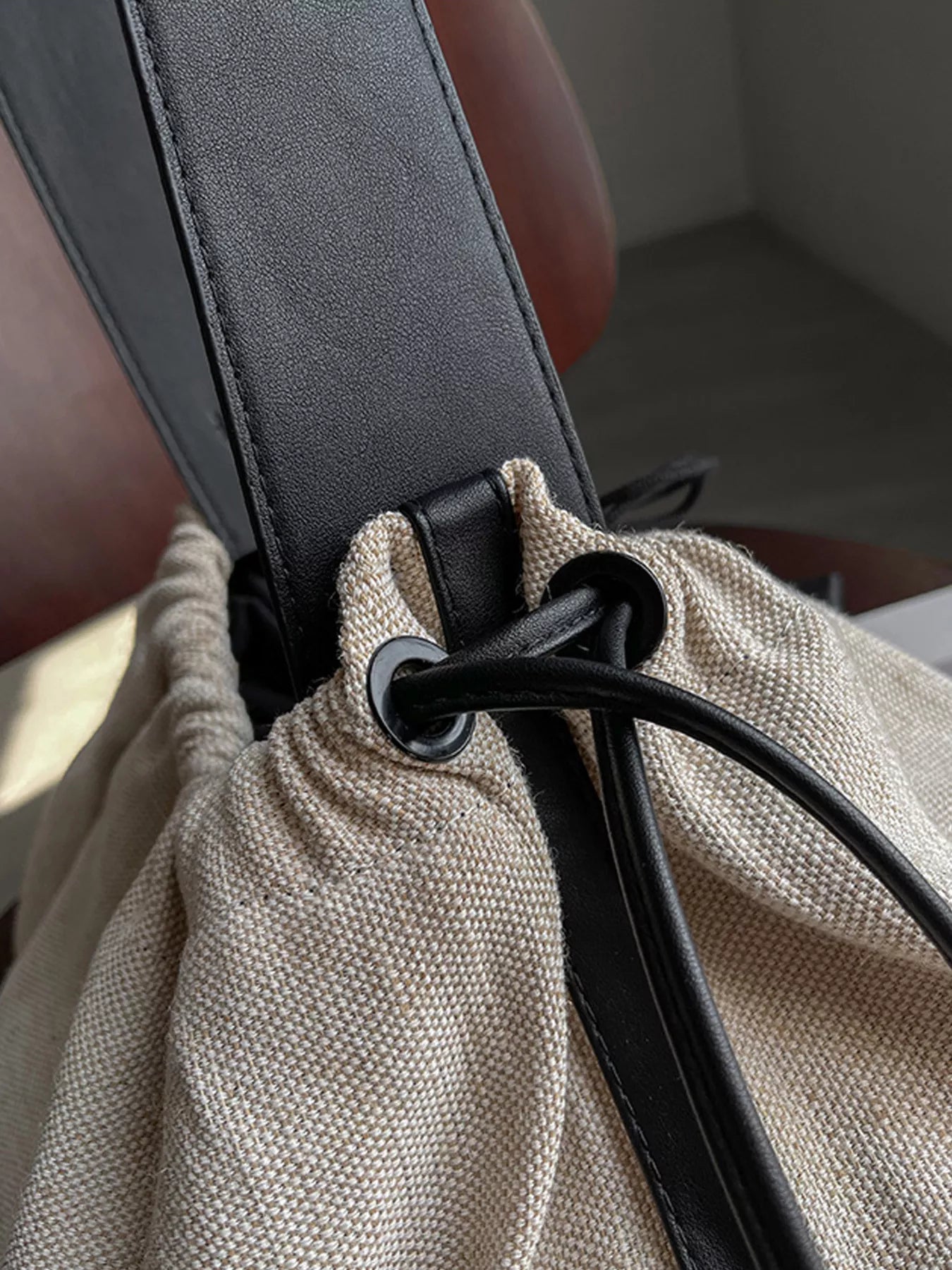 Close-up of a car seat belt being adjusted on a beige fabric surface.