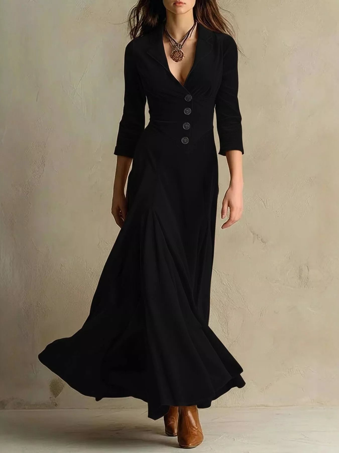 Woman wearing a long black dress with a plain background