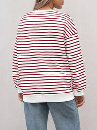 Person wearing a red and white striped sweater with a plain background