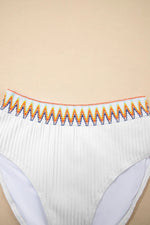 White underwear with colorful trim on a beige background