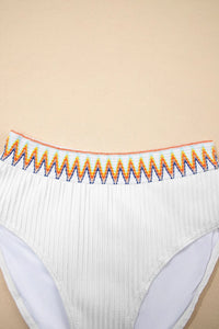 White underwear with colorful trim on a beige background