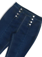 Close-up of blue jeans with button details on a white background