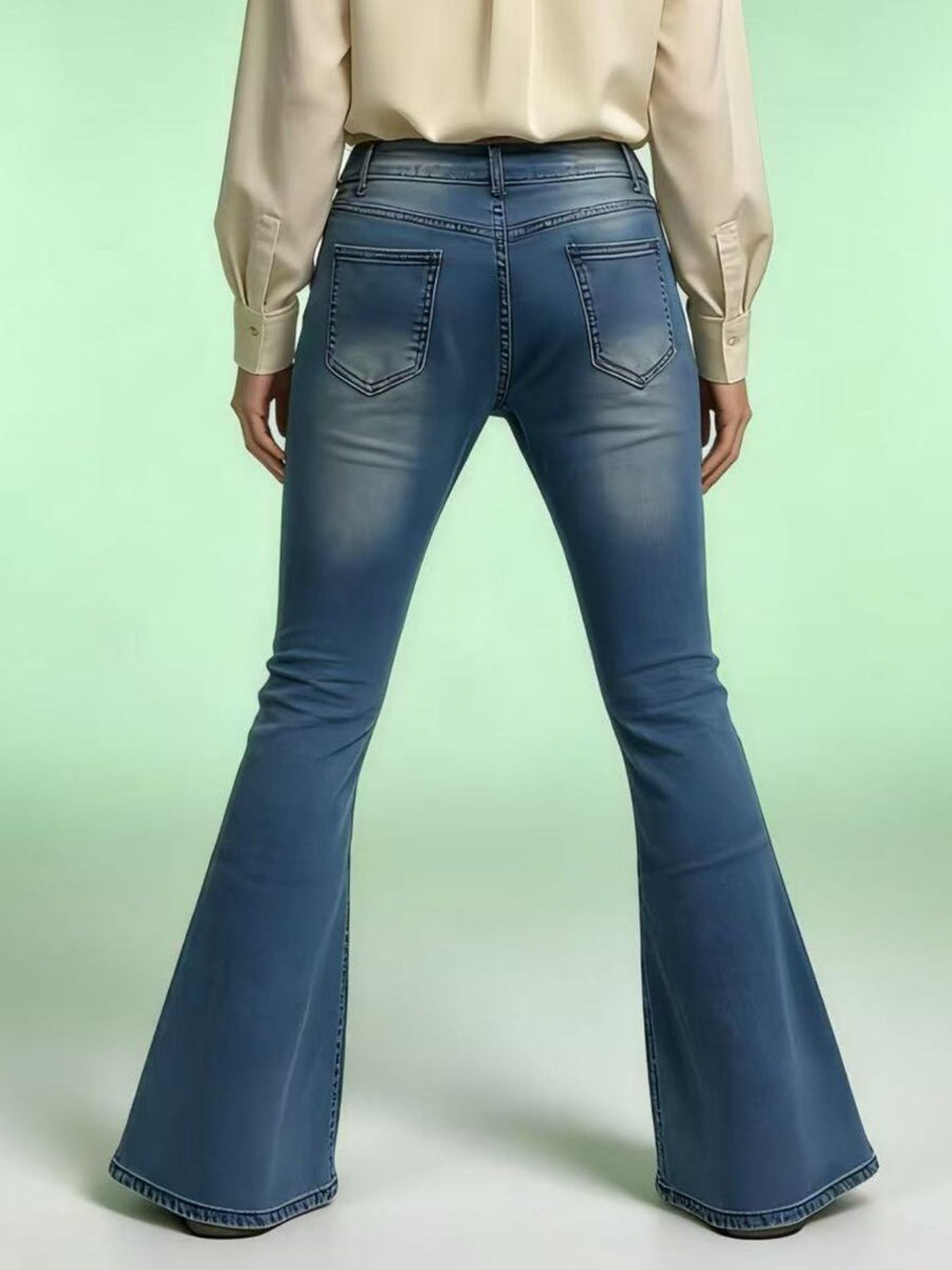 Blue flared jeans worn by a person on a light green background