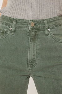 Close-up of green jeans with a neutral background