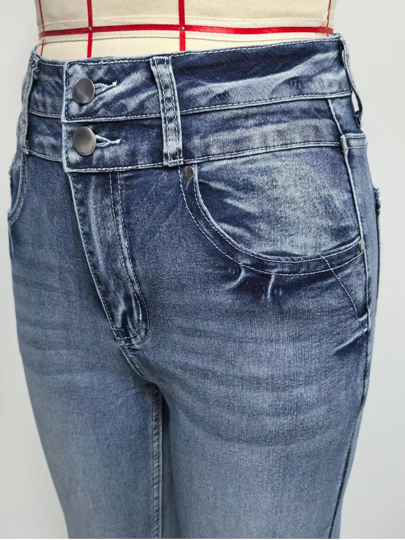 Close-up of blue jeans with a plain background