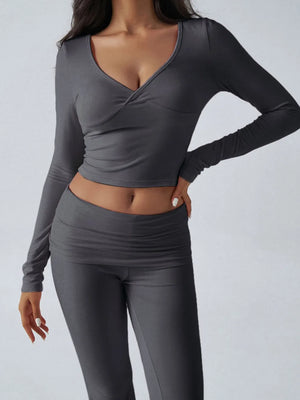 Person wearing a gray long-sleeve top and leggings on a light gray background