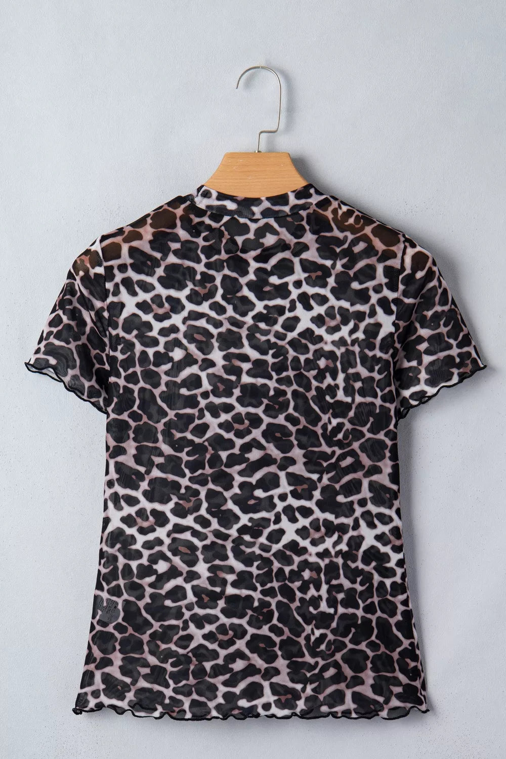 Leopard print dress on a hanger against a light gray background