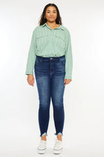 Person wearing a light green shirt and blue jeans on a white background