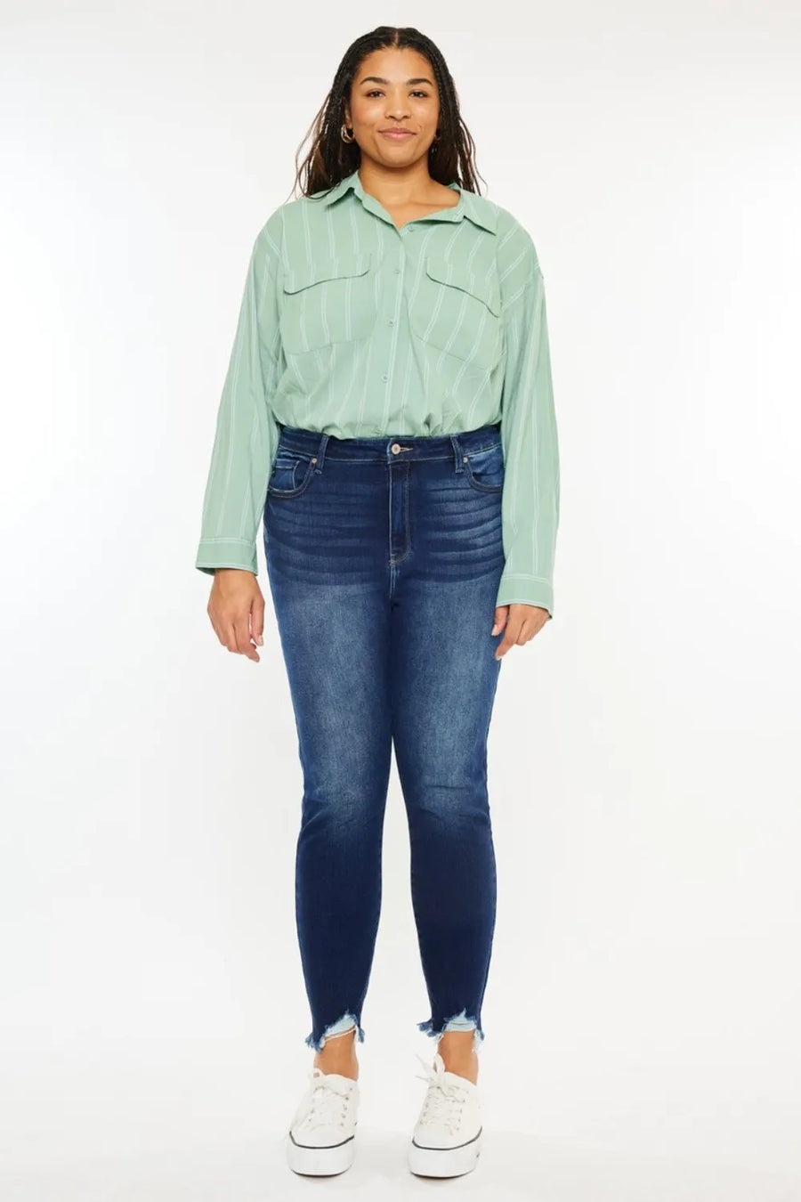 Person wearing a light green shirt and blue jeans on a white background