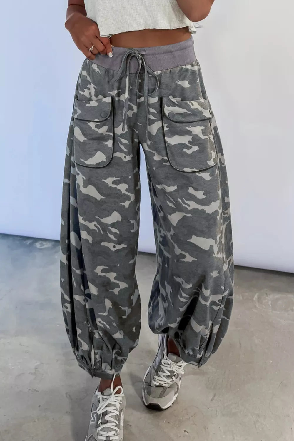 Person wearing camouflage pants with a white background