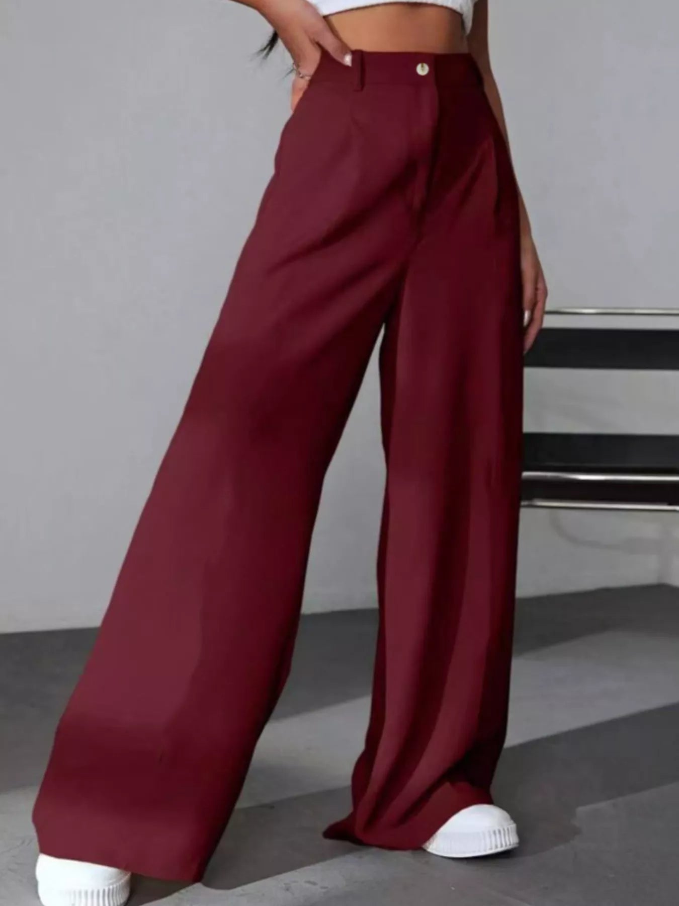Maroon wide-leg pants worn by a person on a gray background