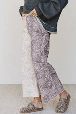 Person wearing leopard print pants and shoes on a plain background