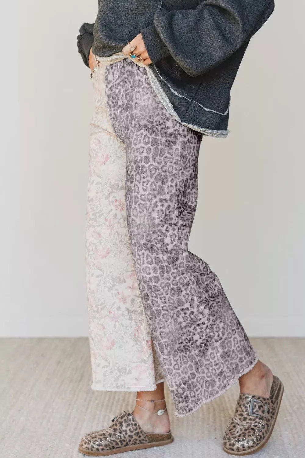 Person wearing leopard print pants and shoes on a plain background