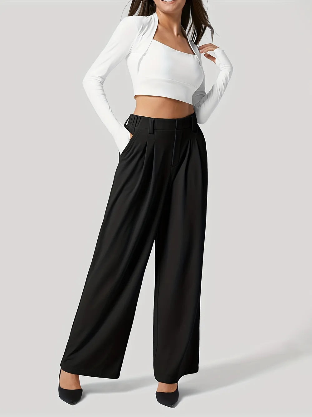 Person wearing a white top and black wide-leg pants on a light gray background