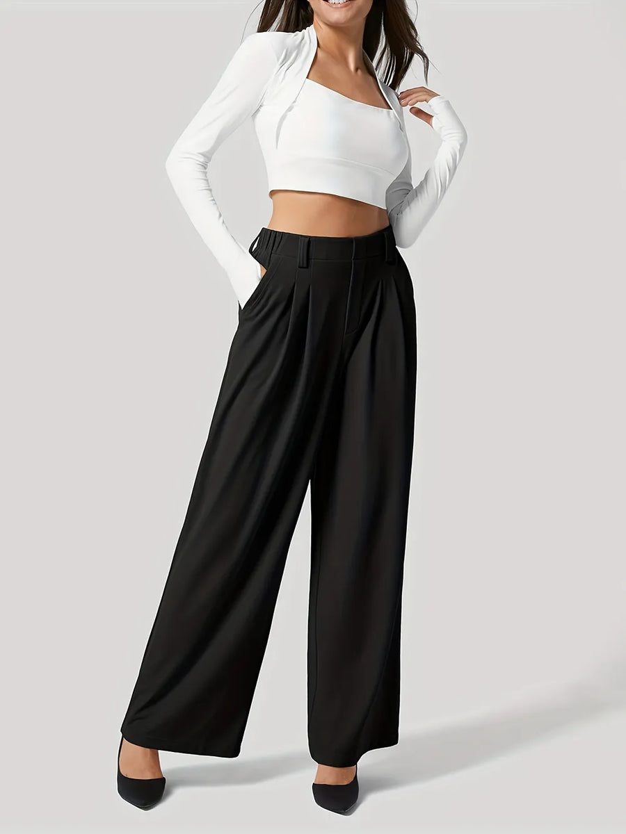 Person wearing a white top and black wide-leg pants on a light gray background