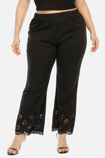 Black pants with lace detailing on a white background