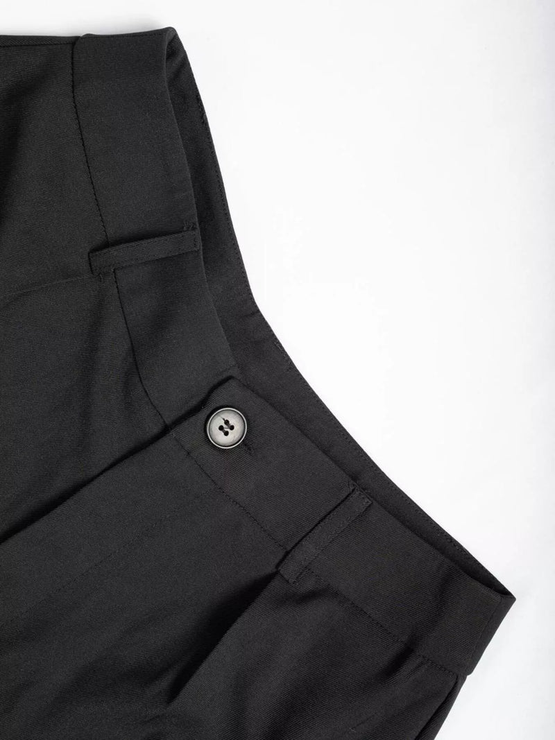 Close-up of black pants with a button on a white background