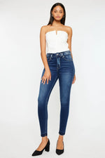 Woman wearing a white strapless top and blue jeans on a white background