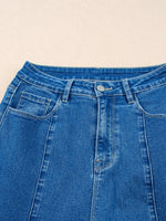 Close-up of blue denim jeans on a beige background