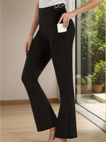 Person wearing black flared pants indoors with a neutral background