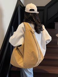 Person with a yellow backpack and white cap walking up a staircase.
