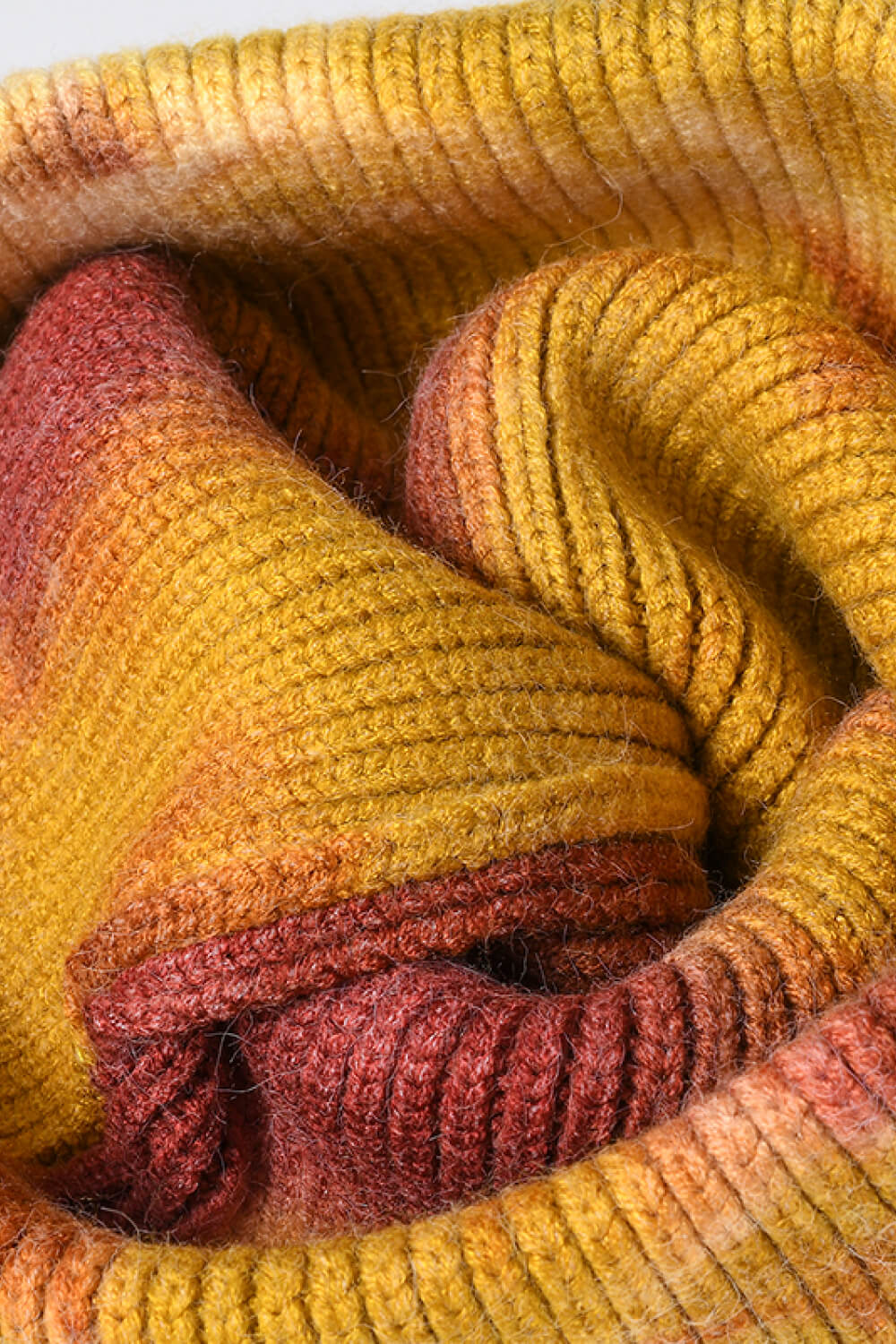 Close-up of a knitted fabric with warm, earthy tones.