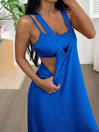 Woman wearing a blue dress with a plunging neckline in an indoor setting.