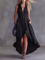 Woman wearing a black dress with a high slit, holding a blue bag against a gray background