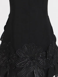 Black dress with floral embroidery on a white background